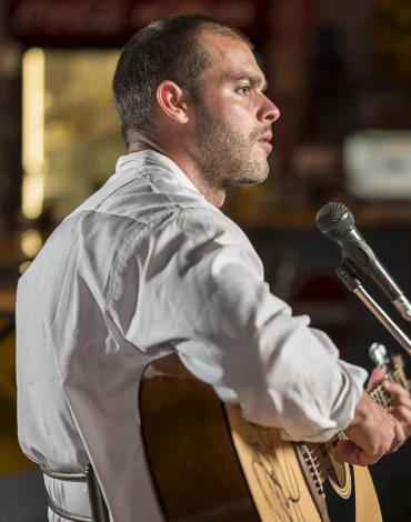 man-playing-guitar-singing-microphone-bar-scaled.webp